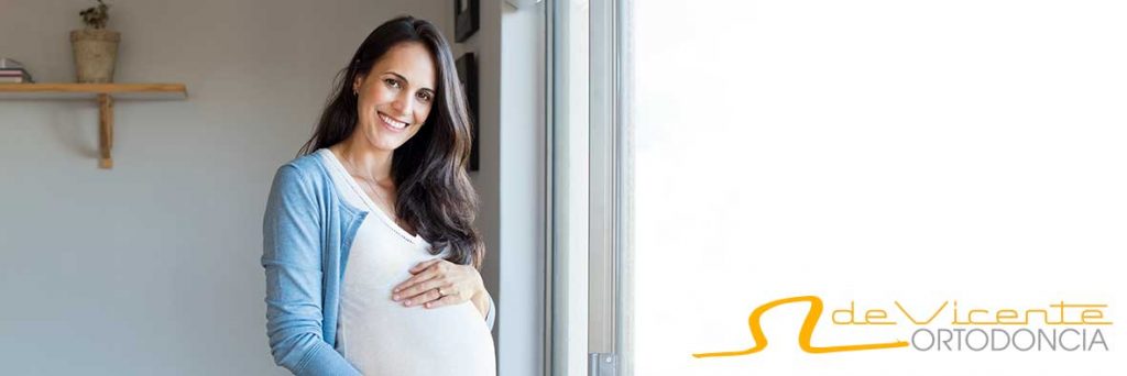 Mujer embarazada sonriente para mostrar salud bucal durante el embarazo